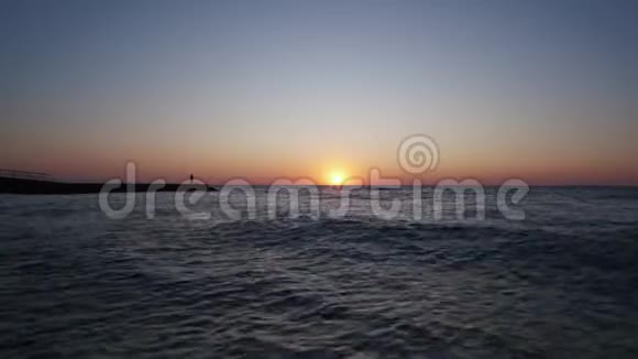 日出时孤独的人海滩上的一个人迎接黎明海波视频的预览图