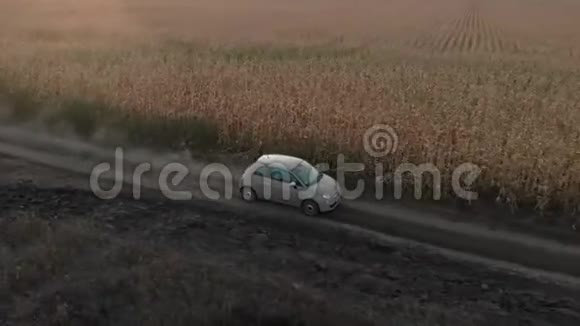一辆小型自行车正行驶在靠近玉米地的乡间尘土飞扬的道路上视频的预览图