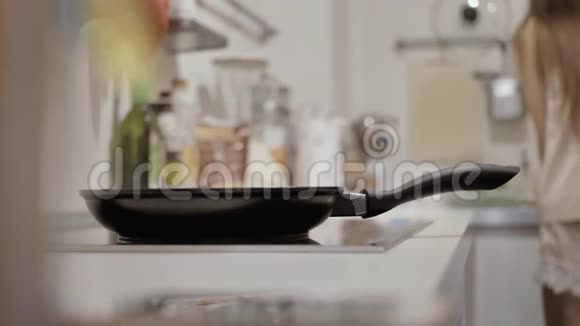 锅在炉子上一个穿着睡衣的女孩在后台洗碗视频的预览图