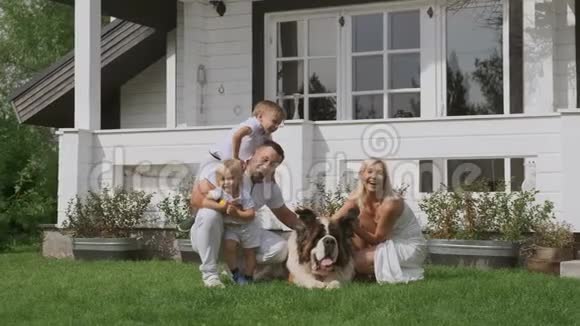 一个年轻的四口之家穿着鲜艳的衣服和一条狗坐在白宫附近玩得很开心视频的预览图