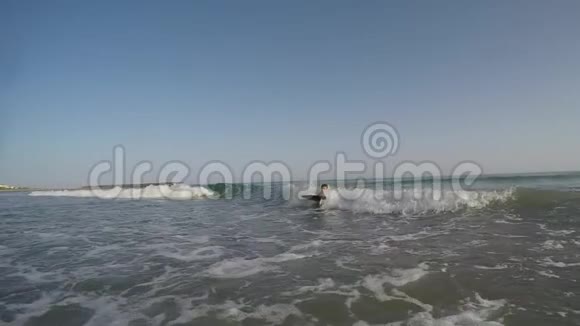 冲浪板上游泳的男孩在海浪中视频的预览图