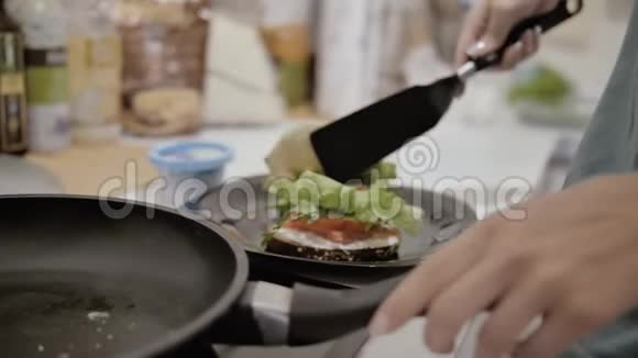 女孩用鸡蛋和生菜做美味的健康三明治视频的预览图