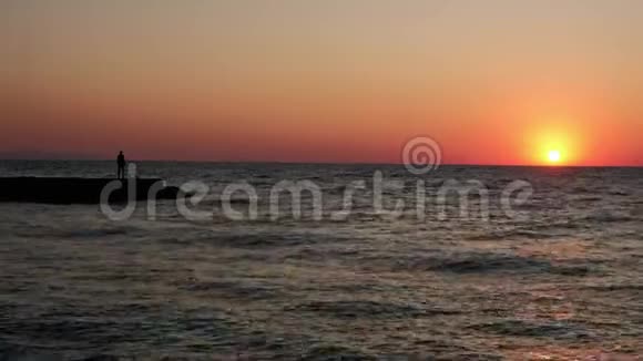 日出时孤独的人海滩上的一个人迎接黎明海波浪波浪波浪波浪波浪波浪浪视频的预览图
