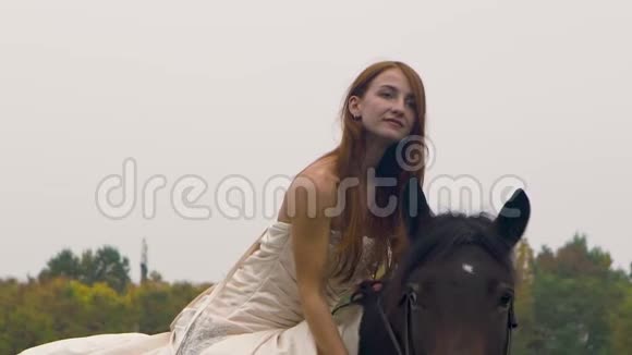 穿着邋遢裙子的姜女骑马在草地上特写视频的预览图