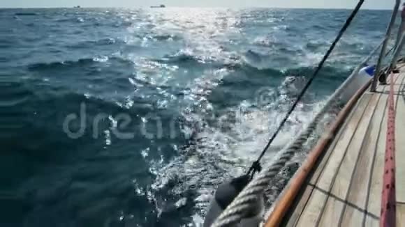 漂亮的木制游艇破浪前行慢镜头清澈的蓝色海水海浪溅起的浪花视频的预览图