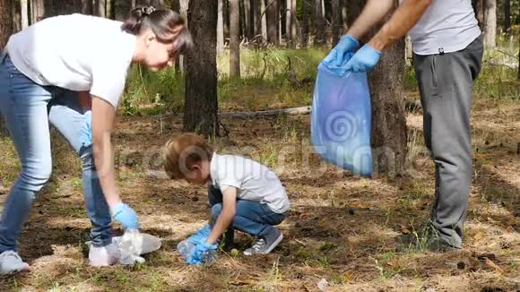 幸福家庭在森林里收集垃圾妈妈和孩子把垃圾放进一个可生物降解的袋子里教育儿童视频的预览图