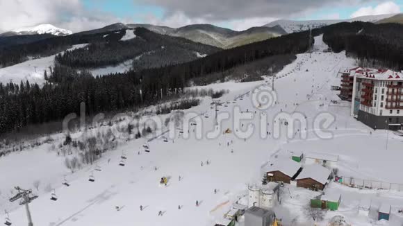在滑雪场滑雪电梯附近的滑雪坡上看到很多人滑雪的空中景色视频的预览图