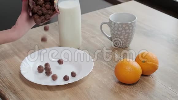 牛奶被倒入碗中巧克力玉米片缓慢地运动牛奶滴在240英尺长的时间内下降到可可麦片粥中视频的预览图