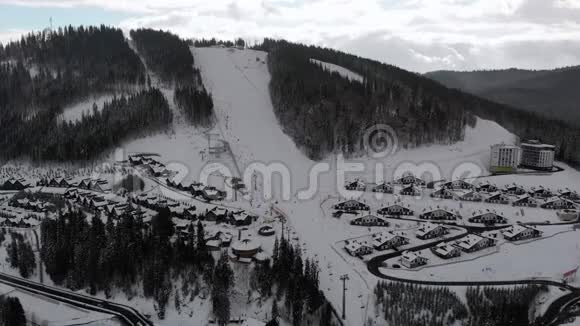 带滑雪板和滑雪板的滑雪胜地的空中景观白雪皑皑的森林Bukvel视频的预览图