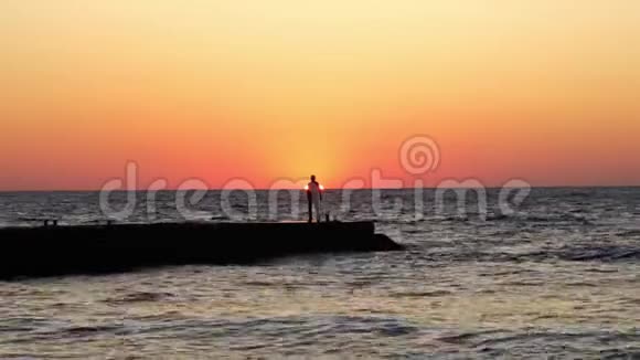 日出时孤独的人海滩上的一个人迎接黎明海波视频的预览图
