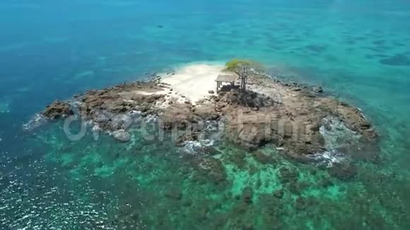 鸟瞰一个热带小岛在一个环礁与美丽的沙滩环绕珊瑚礁热带岛屿视频的预览图