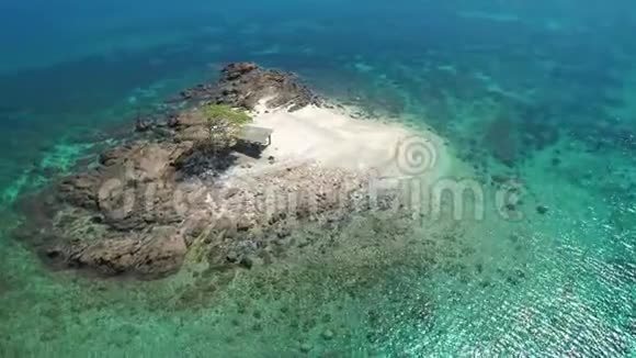 鸟瞰一个热带小岛在一个环礁与美丽的沙滩环绕珊瑚礁热带岛屿视频的预览图