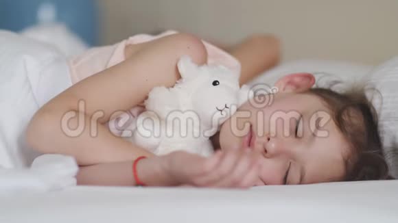 一个熟睡的小女孩的肖像漂亮的孩子和玩具睡觉视频的预览图