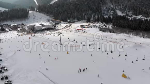 在滑雪胜地滑雪升降机附近的滑雪斜坡上滑雪者的鸟瞰图视频的预览图