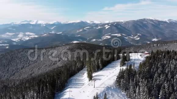 滑雪场上有滑雪者和滑雪升降机的空中滑雪斜坡雪山森林视频的预览图