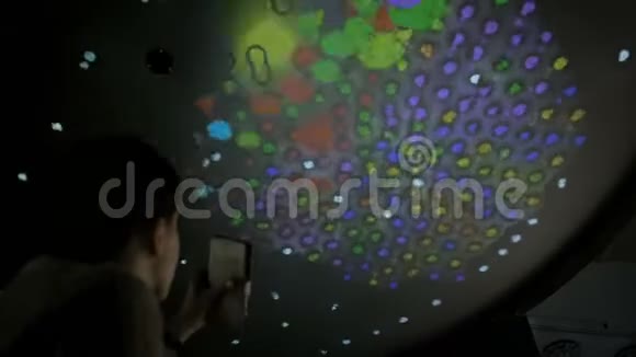 使用带手电筒的智能手机与多媒体天花板互动的女人视频的预览图