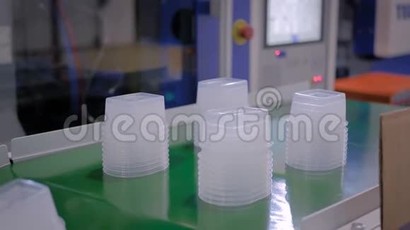 自动机器人生产线传送带上装有塑料食品容器视频的预览图