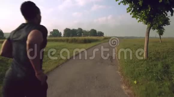 年轻的非洲运动员在大自然中奔跑的背影视频的预览图