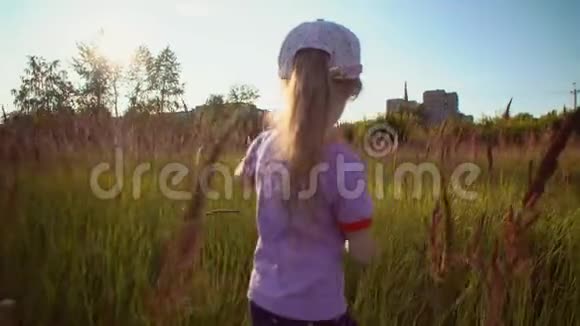 小可爱的金发女孩穿过高高的花草穿过田野视频的预览图