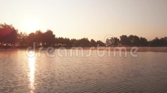 太阳在湖中反射日出时有晨雾视频的预览图