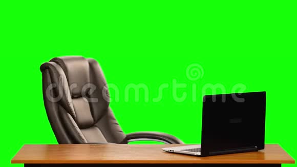 空办公室皮革商务椅在一张带有笔记本电脑的桌子附近旋转绿色屏幕视频的预览图