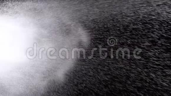 黑色背景上的喷水空气中的水滴慢动作视频的预览图