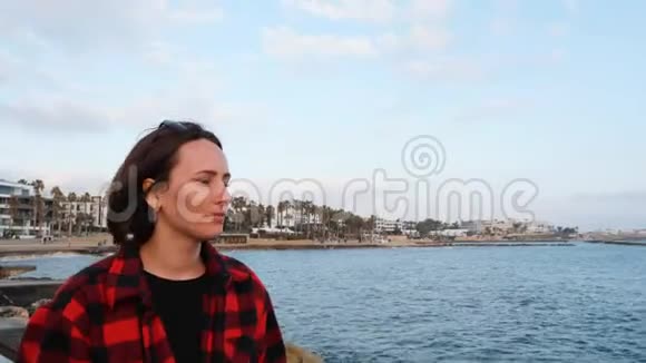 孤独的年轻黑发女人在海边度假日落时分悲伤迷人的女性沿着海滨散步近景视频的预览图
