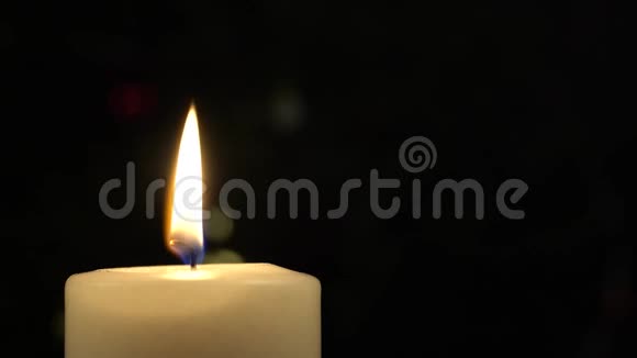 用金光背景模糊的白色燃烧的蜡烛在桌子上合上视频的预览图