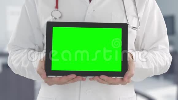 医生拿着绿色屏幕的现代平板电脑用红色相机拍摄阿尔法哑光便于图片或视频放置视频的预览图