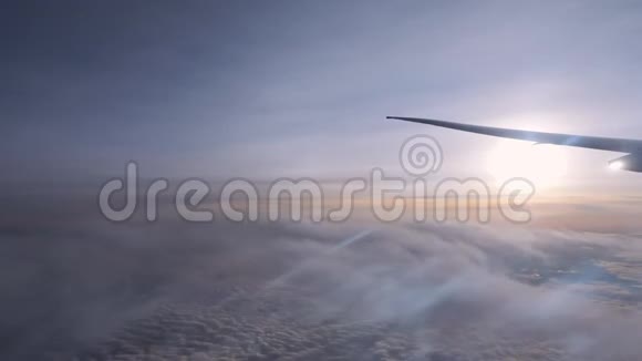 在无边无际的地平线上在飞机翼下的云层上视频的预览图