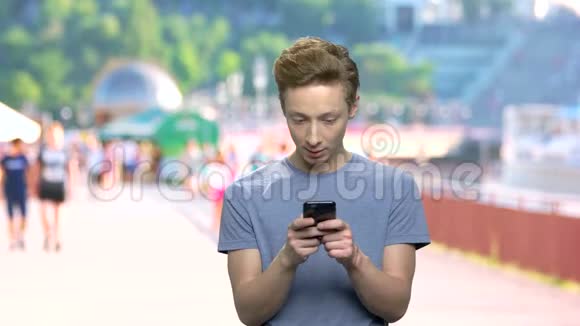 一个十几岁的男孩在手机上发短信视频的预览图