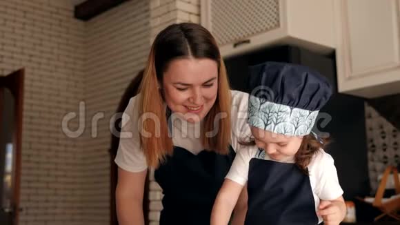 妈妈和女儿吃生饼干面团在厨房里在家笑视频的预览图