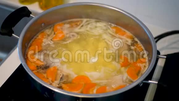 女厨师将热鸡和蔬菜汤中的配料和黄色透明盖子的金属丝锥视频的预览图