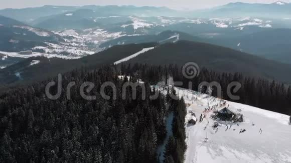 滑雪场上有滑雪者和滑雪升降机的空中滑雪斜坡雪山森林视频的预览图