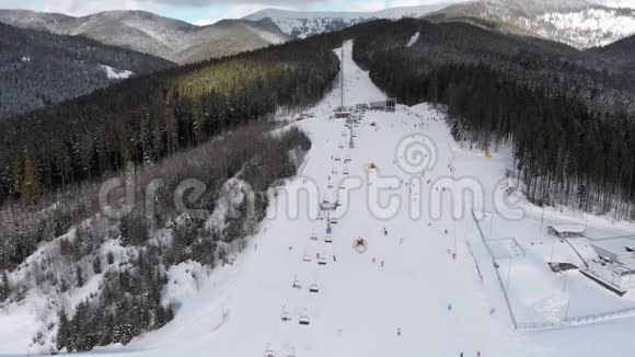 滑雪场上有滑雪者的空中滑雪坡雪山杉林Bukvel视频的预览图