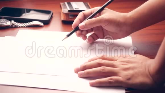 男经理把他的想法和商业计划写在工作场所男人拿着铅笔在t上的纸质文件中做笔记视频的预览图