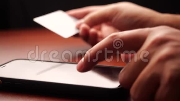 男性手举信用卡使用手机上网购物视频的预览图