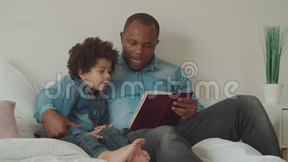 黑人父亲在床上给小儿子读故事视频的预览图