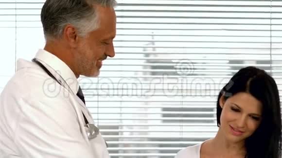 医生给怀孕的病人看药片视频的预览图