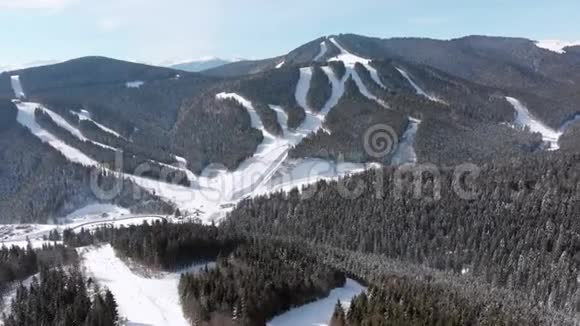 滑雪场上有滑雪者和滑雪升降机的空中滑雪斜坡雪山森林视频的预览图