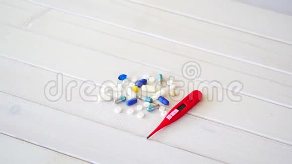 白色桌子上的一套不同的药丸和温度计视频的预览图