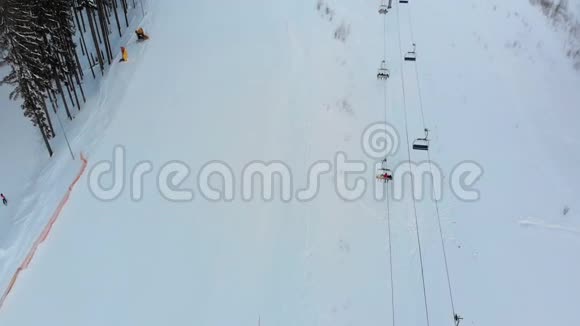 冬季滑雪场有滑雪者和滑雪升降机的滑雪斜坡的空中景观视频的预览图