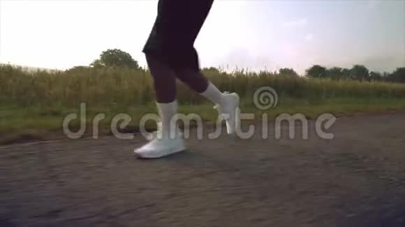 穿着短裤和运动鞋在绿野间奔跑的壮汉视频的预览图