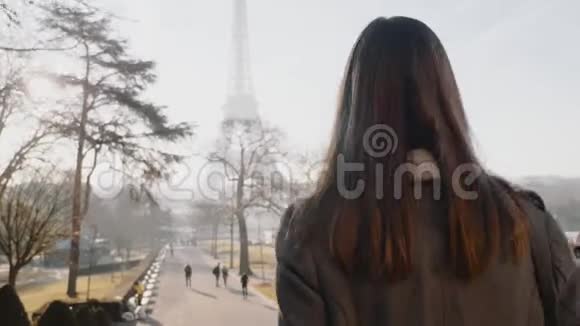 镜头跟随幸福优雅的女人沿着秋天的巴黎走向著名的埃菲尔铁塔在商务旅行中慢动作视频的预览图
