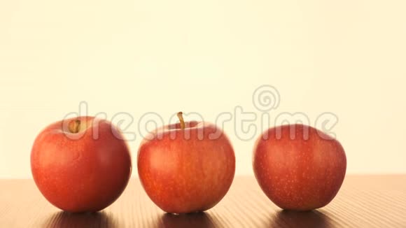 苹果排在一张白色背景的桌子上中间的苹果上下起伏前视图视频的预览图