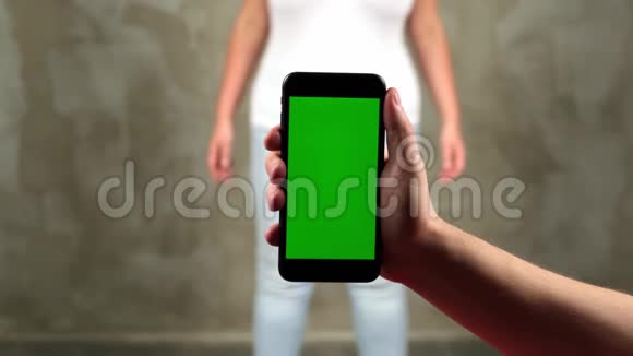 男人手拿着一部带有垂直绿色屏幕的移动电话这是有轨电车色度关键智能手机技术手机视频的预览图