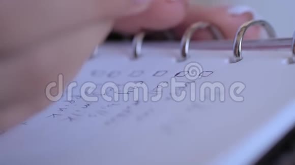 女人在笔记本上的做的清单复选框上加上标记关闭视频的预览图