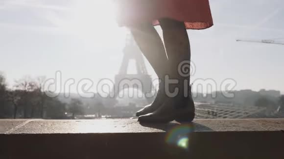 电影院低角度移动美丽微笑的女人穿着红色的裙子行走摆在阳光明媚的埃菲尔铁塔附近缓慢的运动视频的预览图