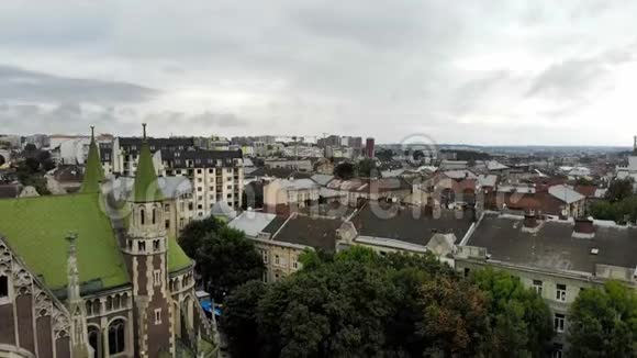 利沃夫的城市景观鸽子飞到老教堂附近利沃夫市的地标和建筑很受欢迎的旅游场所空中钻孔机视频的预览图