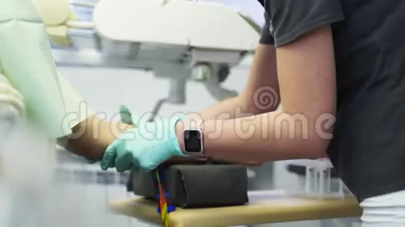 护士在病人手臂上戴上血止血带女医生穿着制服准备验血视频的预览图
